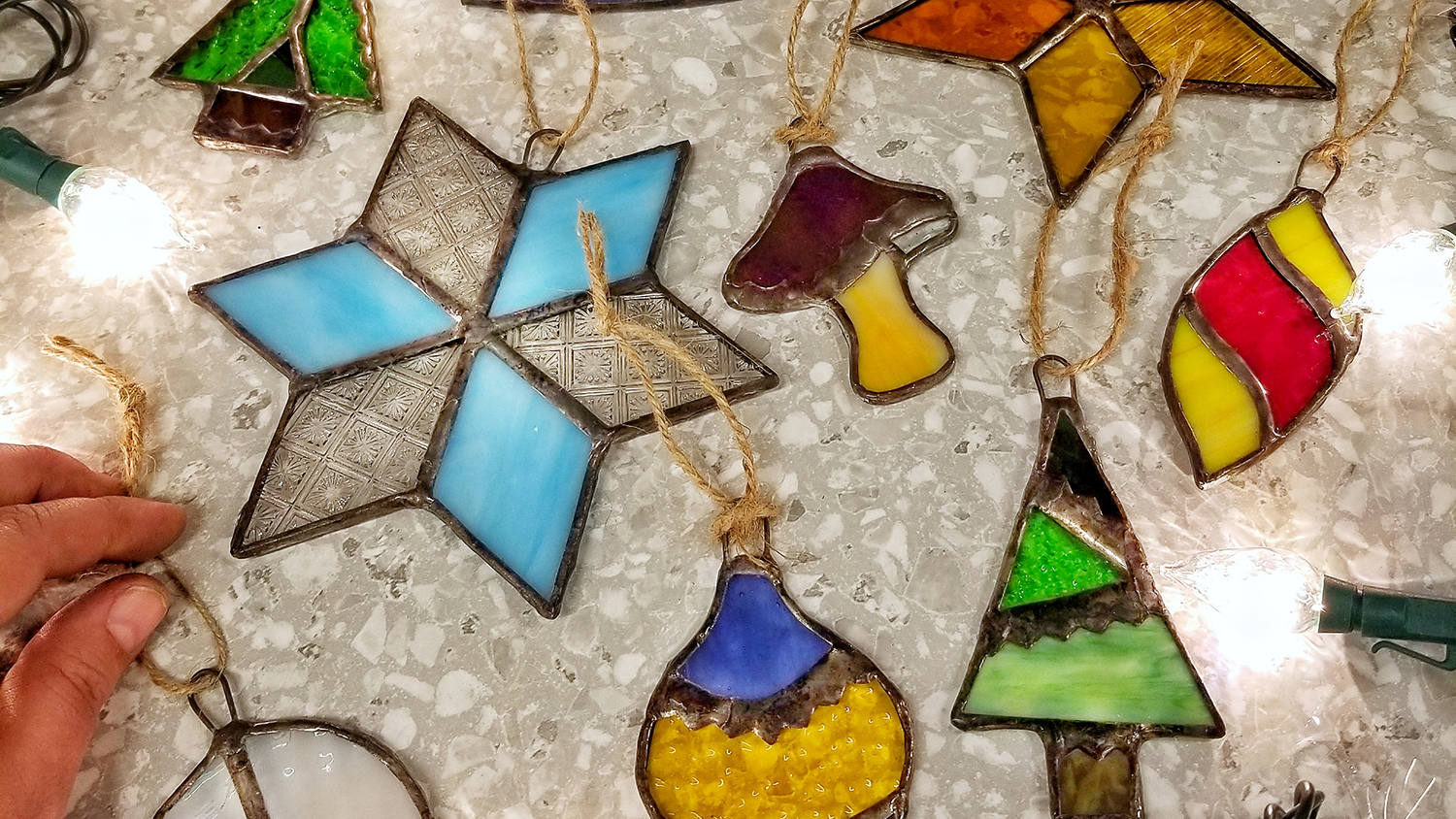Several stained glass hanging ornaments lay on a table.