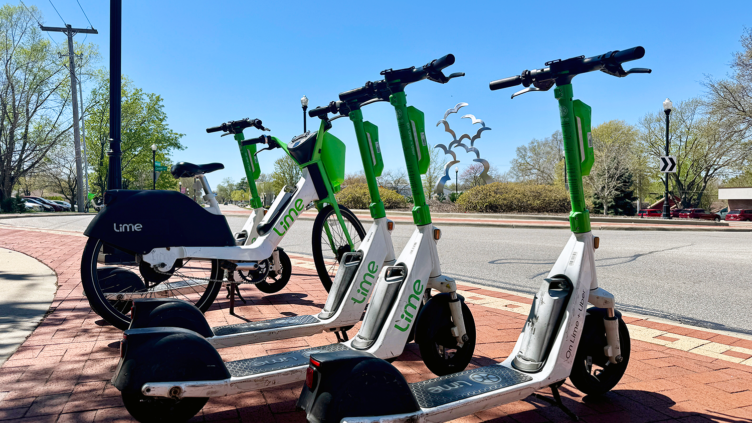 A row of parked Lime e-scooters and bikes.