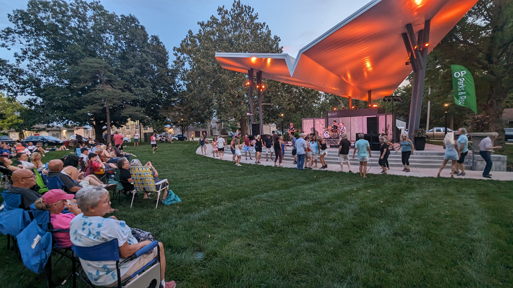 A crowd enjoys live music at the Thompson Park stage while others dance.