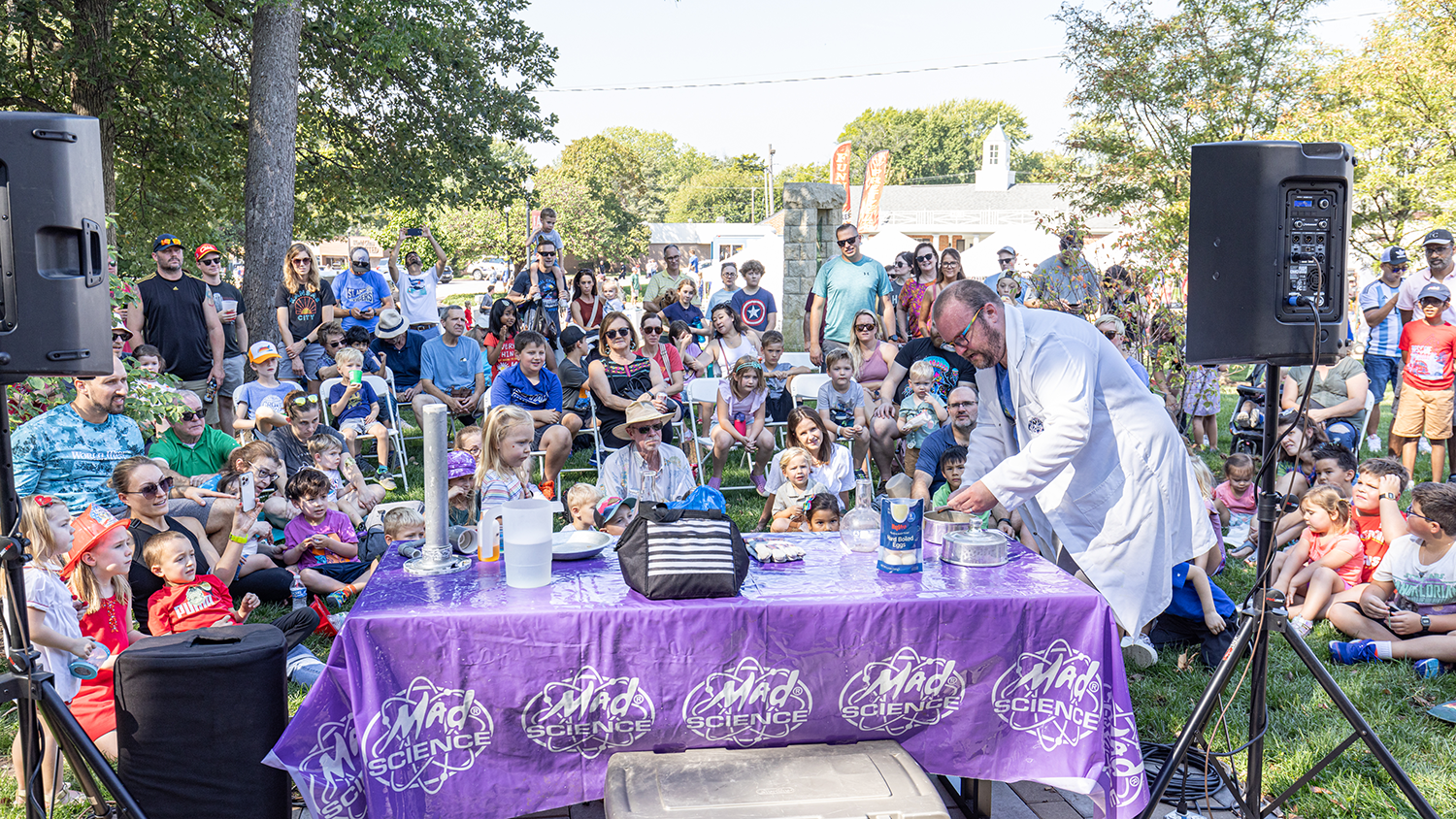 Mad Science demonstrates an experiment in front of a crowd of children.