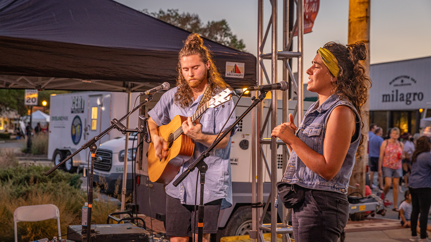 A man plays guitar while a women sings during a performance in Downtown Overland Park.