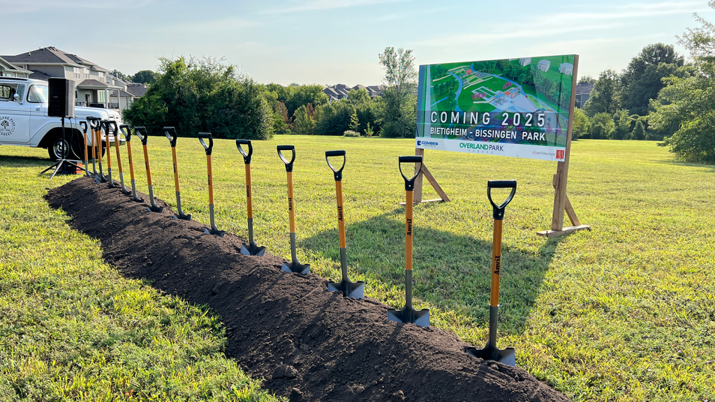 A line of shovels standing in dirt ahead of the groundbreaking ceremony.